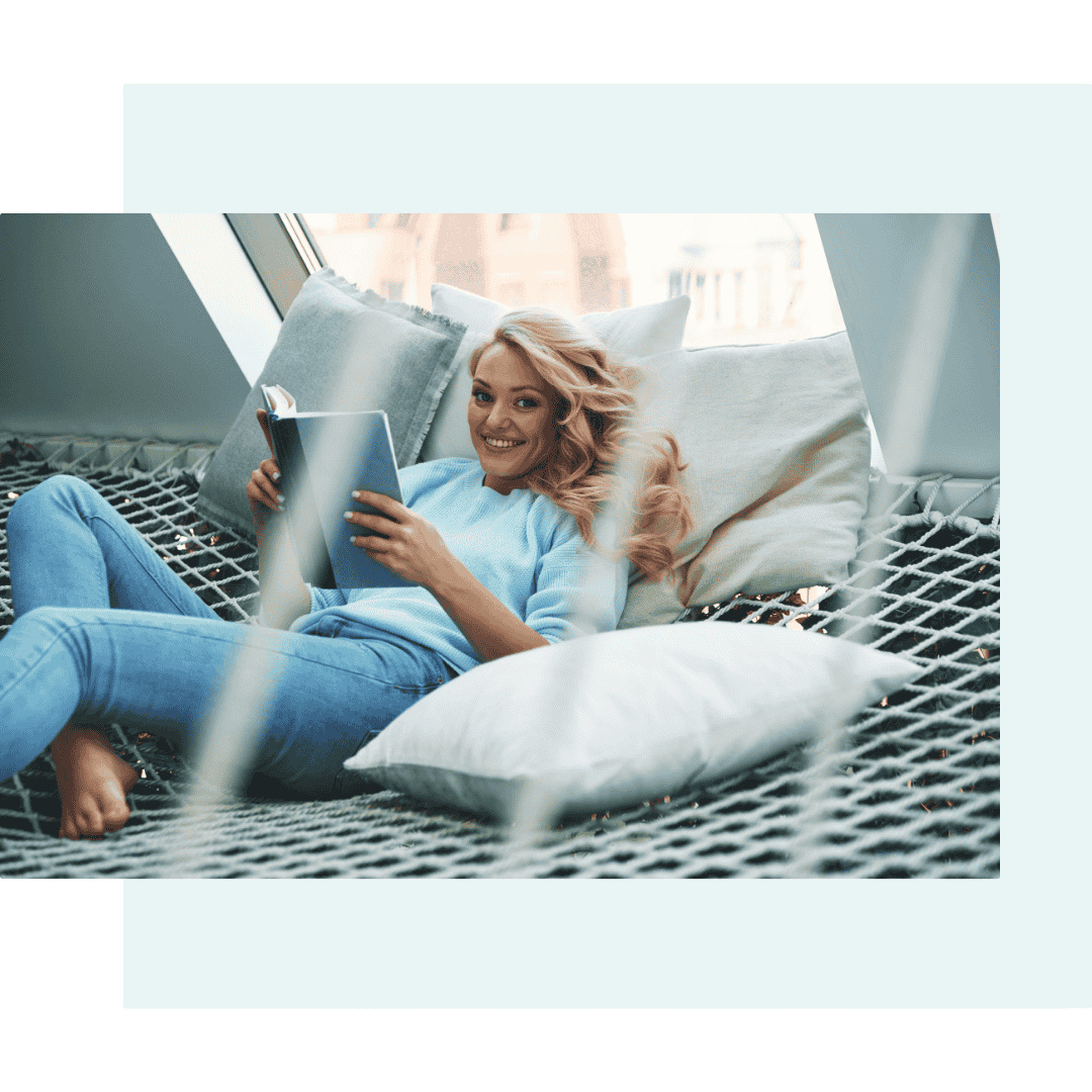 Woman relaxing with tablet on cozy indoor hammock